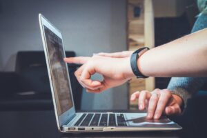 Title image showing a person pointing at a laptop