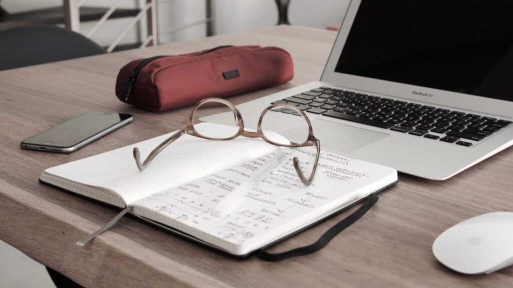 Title Image showing a notebook, a laptop and glasses